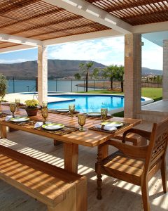 piscine avec vue sur mer et montagne avec terrasse en bois et table de réception